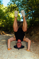 Young guy doing headstand on the road in nature © qunica.com