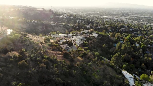 Aerial fly over hill side homes and the San Fernando Valley.