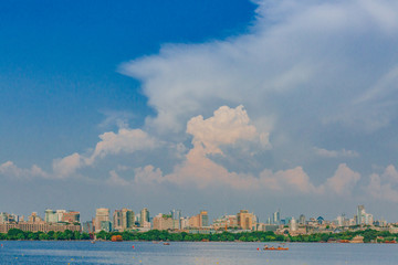Skyline of Hangzhou over West Lake under clouds and sky, in Hangzhou, China