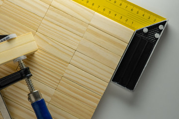 Building tools: corner ruler and clamp with wooden blocks background