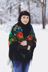 Young beautiful brunette girl in a sweater in the winter snowy forest