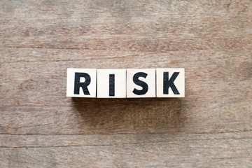 Fototapeta premium Wood letter block in word risk on wood background