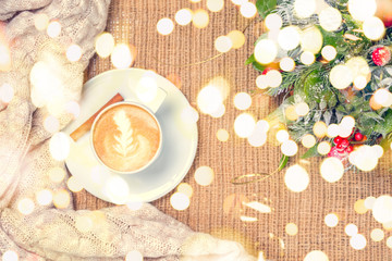 Cup of coffee or chai tea with latte art and Christmas decor. Leisure time concept. Pastel colors. Festive bold bokeh