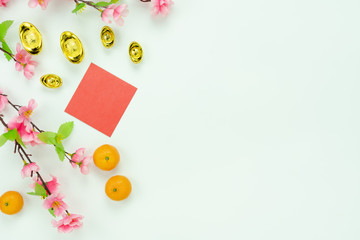 Chinese language mean rich or wealthy and happy.Top view decoration Chinese new year & lunar new year holiday background concept.Flat lay orange with pink flower on white wooden at home office desk.