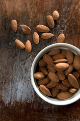 Top View of Seasoned Almonds ina White Bowl with Weathered Wood Background