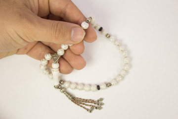 Muslim male hands holding rosary on white background