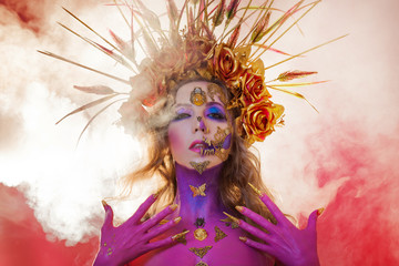 Bright Halloween image, Mexican style with sugar skulls on face. Young beautiful woman bright pink...