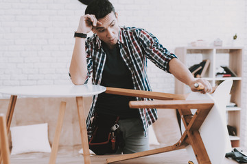 Young Man Assembling Coffee Table and Stools.