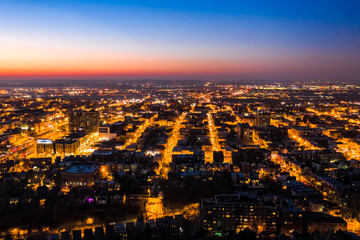 Aerial view of Hoboken, New Jersey at dusk, with illuminated streets converging towards the horizon