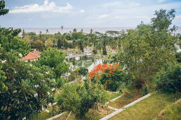 Panoramic view of the Royal water palace in Taman Ujung park which is situated near the ocean, Bali, Indonesia