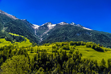 Fototapeta na wymiar Fields with houses in Swiss Alps mountains, Moerel, Filet, Oestlich Raron, Switzerland