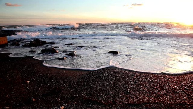 Atlantic Ocean waters wash up upon the shore in Cape Cod during a beautiful sunset.