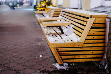 Brown wooden benches at christmas fair in nightly city