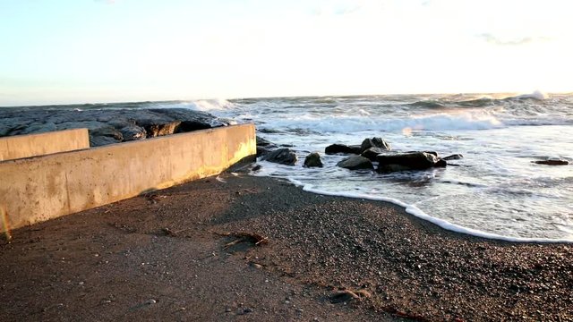 Atlantic Ocean waters wash up upon the shore in Cape Cod during a beautiful sunset.