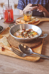 Breakfast fried eggs with sausage and toast in a small pan.