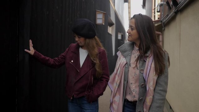 Two  fashionable female friends admiring an old street in kyoto