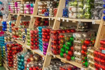 Sale of Christmas toys in the supermarket. Balls of different colors for the Christmas tree on the supermarket shelves. 