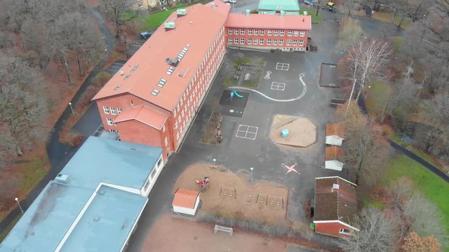 Aerial video flying in over a schoolyard and school in Gothenburg, Sweden