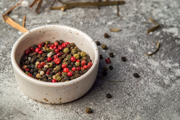 Close up. A beige bowl filled with fragrant colorful peppercorns. Copy space.