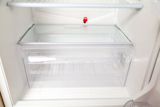 transparent box stands bottom of  empty refrigerator
