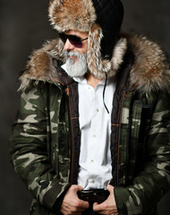 brutal senior millionaire man in white shirt winter hat and jacket in aviator sunglasses stylish fashionable men