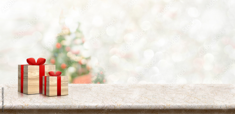 Poster gift box on white marble table top at blur bokeh christmas tree decor with string light background w