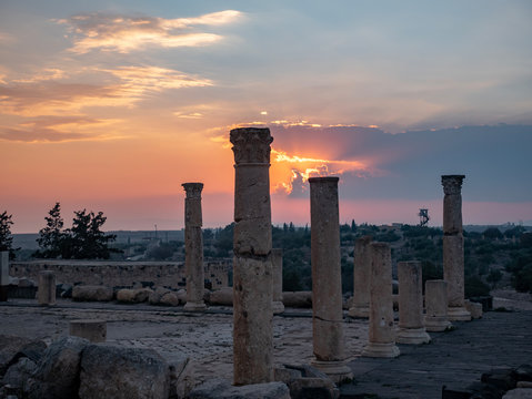 Pillars of a Roman temple against a a golden sunset