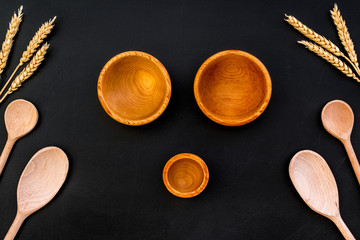 Village table with wooden cutlery set black background top view