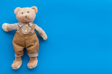 Craft toys for kids. Handmade teddy bear. Blue background top view mock up
