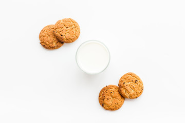 Drink milk with cookies concept. Cup of milk and fresh homemade cookies on white background top view space for text