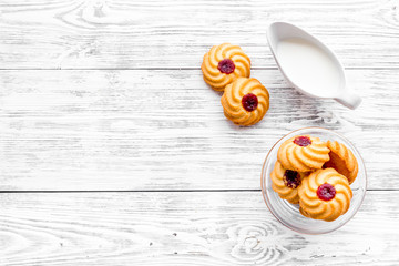 Drink milk with cookies concept. Cup of milk and fresh homemade cookies on white wooden background top view copy space