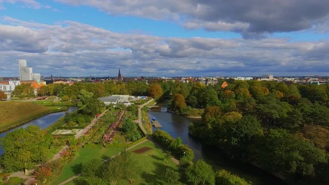 Aerial shot of beautiful flower garden at Slottsparken with canals and cityscape in Malmoe Sweden in 4k.