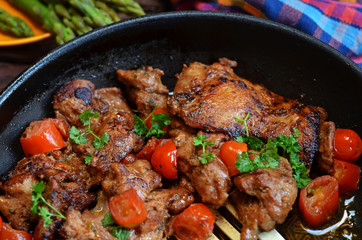 Fried chicken with cherry tomatoes in a pan