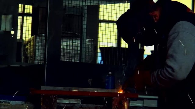 Man in workshops doing mig welding in slow motion