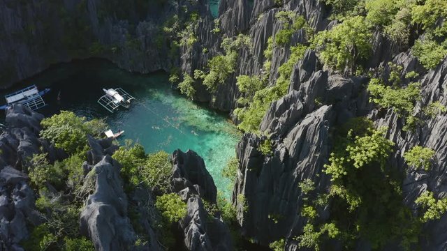 Flying above rocks, water and boats in the Philipines