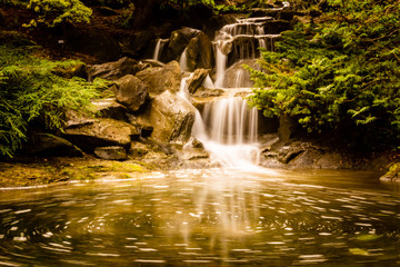 Fototapeta na wymiar beautiful waterfall with blurry water in the garden.