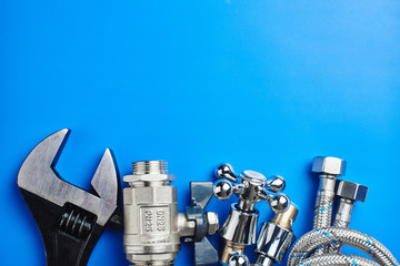 plumbing tools and equipment on blue background with copy space
