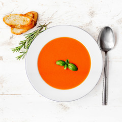 Tomato soup on a white rustic table,. Flat lay.  Copyspace