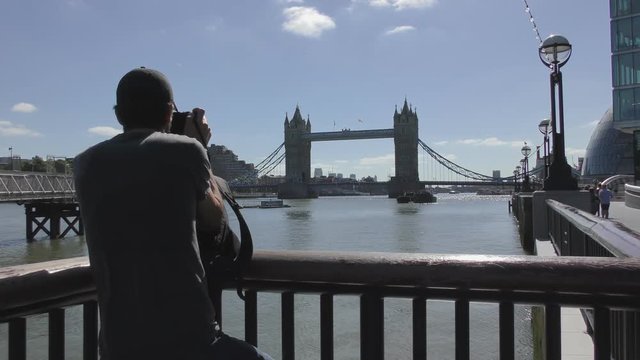 London. A tourist taking picture of the Tower Bridge.