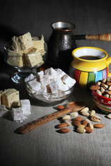 A mug of coffee and different oriental sweets: turkish delight, halva, almond and pistachio