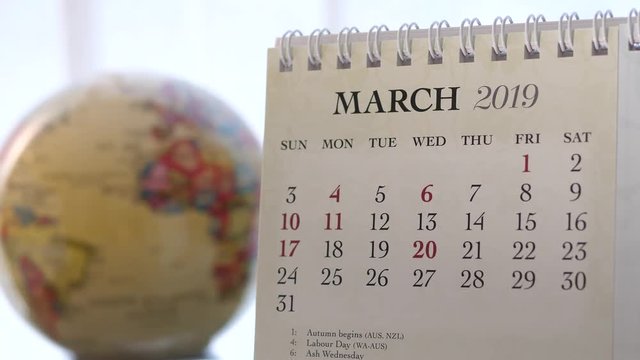 Motion of March 2019 calendar with blur earth globe turning background