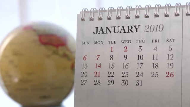 Motion of January 2019 calendar with blur earth globe turning background