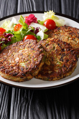 Delicious mushroom vegetable patties served with fresh salad on a plate close-up. vertical
