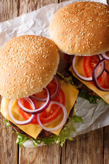 veggie sandwich with mushroom patty, vegetables and cheddar cheese close-up. Vertical top view