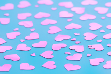 Blue background with pink hearts confetti for Valentine's day. Selective focus.  Festive and holiday concept.