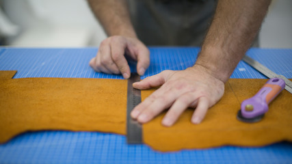 Hands of the master. Marking leather for making bags, purses or shoes.