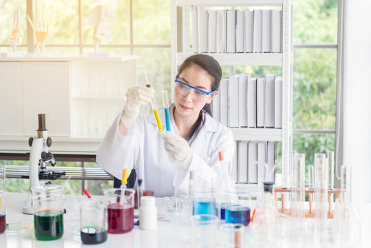 Scientist female working putting medical chemicals sample in test tube at laboratory