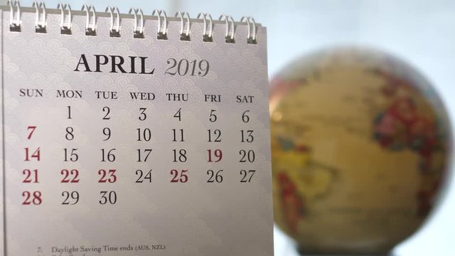 Motion of April 2019 calendar with blur earth globe turning background