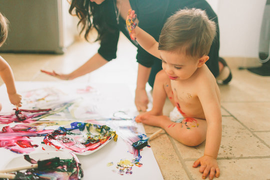 A little boy making a mess with paint at home. 