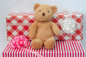Teddy bear sitting amid a gift box. For Christmas and New Year.